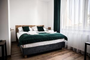 - une chambre avec un lit doté de draps verts et une fenêtre dans l'établissement Apartamenty W Centrum Chrzanowa, à Chrzanów