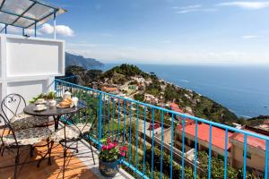 uma varanda com uma mesa e cadeiras e o oceano em Casa Bellavista em Amalfi