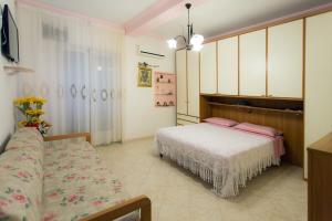 een slaapkamer met een bed en een bank erin bij Casa Bellavista in Amalfi