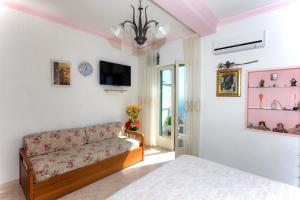 een woonkamer met een bank en een tv bij Casa Bellavista in Amalfi
