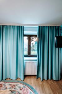 Zimmer mit blauen Vorhängen und einem Fenster in der Unterkunft The Cypress Villa & Vineyard II in Sremska Kamenica