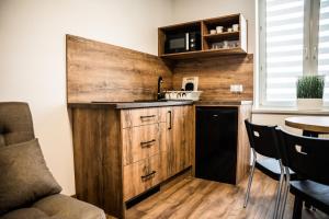 - une cuisine avec des placards en bois, une table et des chaises dans l'établissement Apartamenty W Centrum Chrzanowa, à Chrzanów