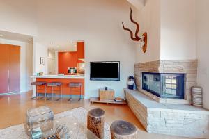 a living room with a fireplace and a flat screen tv at Modern Park City Condo in Park City