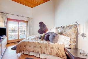 a bedroom with a bed with a desk and a television at Modern Park City Condo in Park City