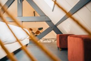 Zimmer im Dachgeschoss mit Holzdecke und rotem Sofa in der Unterkunft Suite Léonard _ Résidence Isaelle in Bray-Dunes