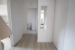 een kamer met witte muren en een hal met een spiegel bij Le Léon Ungemach - Studio à Schiltigheim in Schiltigheim