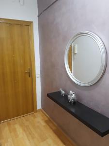 Ein Spiegel an der Wand neben einer schwarzen Theke in der Unterkunft Room in shared appartment close to Camp Nou in Hospitalet de Llobregat