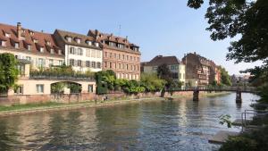 un río en una ciudad con edificios y un puente en 4 Quai des Pêcheurs - Charmant duplex sur les quais, en Estrasburgo