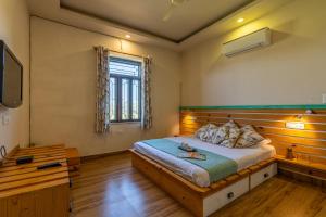 Un dormitorio con una cama grande y una ventana en GiriSadan Organic Farm Retreat & Botanical Forest en Jaipur