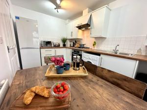a kitchen with a wooden table with a bowl of fruit at Dale House by Blue Skies Stays in Middlesbrough
