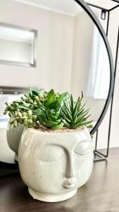 eine weiße Vase mit einer Pflanze auf dem Tisch in der Unterkunft Apartament na Brudzewskiego in Przemyśl