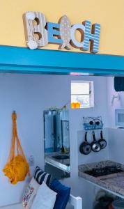 une étagère avec le mot vie dans une cuisine dans l'établissement Pipa Beach House Chalés, localizada ao lado do Mirante Sunset Bar, à Pipa