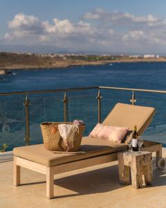 einen Stuhl und einen Tisch auf einem Balkon mit Meerblick in der Unterkunft Villa Anton by Cura Villas Collection in Kalathas