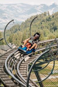 a man and a child sitting on a roller coaster at La Pierre à Catillon in Moleson