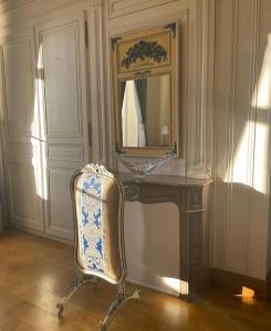 a chair in a room with a mirror and a vanity at Les Gîtes du Domaine de la Traxène in Coupelle-Vieille