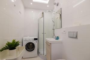 biała łazienka z pralką i umywalką w obiekcie ShortStayPoland Batorego (B139) w Warszawie