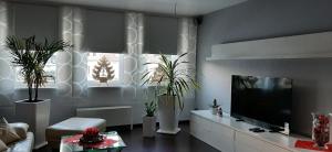 a living room with a flat screen tv and plants at Ferienwohnung im grünen Muldental in Langenbach