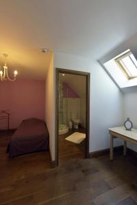 una camera con letto e un bagno con finestra di Les Gîtes du Domaine de la Traxène a Coupelle-Vieille