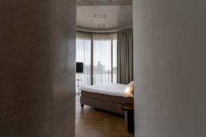a hotel room with a bed and a large window at Hotel Pontsteiger in Amsterdam