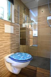 a bathroom with a toilet with a blue seat at Petit chalet " L' Oiseau de Paradis " in Fréjus