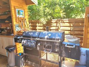 a large grill in a kitchen with a table at Petit chalet " L' Oiseau de Paradis " in Fréjus
