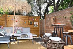 a patio with a couch and chairs and a table at Petit chalet avec terrasse proche plage in Fréjus