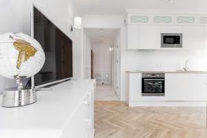 a white kitchen with a globe on a counter at Flatbook - Old Town Deluxe Apartments Sauna & Parking in Gdańsk