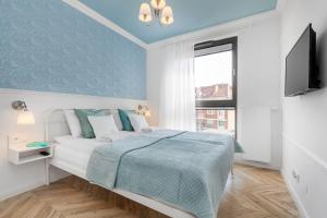 a bedroom with a bed with a blue wall at Flatbook - Old Town Deluxe Apartments Sauna & Parking in Gdańsk