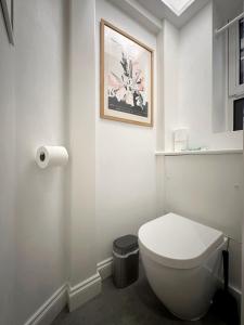 a bathroom with a toilet and a picture on the wall at David’s Place in EastEnd in London
