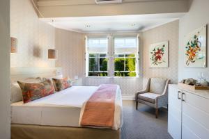 a bedroom with a bed and a window and a chair at Welgelegen House in Cape Town