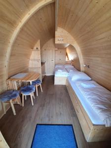 ein Zimmer mit Betten und einem Tisch in einem Holzzimmer in der Unterkunft Ferienpark Auf dem Simpel - Schnuckenbude 2 in Soltau
