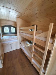 1 Schlafzimmer mit 2 Etagenbetten in einem Blockhaus in der Unterkunft Ferienpark Auf dem Simpel - Schäferwagen 4 in Soltau