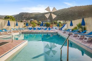una piscina con sillas y sombrillas en un complejo en Paradise Hotel-Apartments, en Stalida