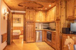 a kitchen with wooden cabinets and a stove top oven at Casa Lacedel 2, on ski slopes in Cortina dʼAmpezzo