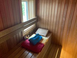 una pequeña sauna con taburete rojo y almohada azul en Relax Home ®Rajna®, en Korenica