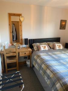 a bedroom with a bed and a desk and a mirror at Jacquie's B&B -Dumfries-Room with a view - hot tub in Dumfries