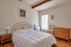 Un dormitorio con una gran cama blanca y una ventana en Echappee insulaire tout pres de la plage, en Sainte-Marie-de-Ré