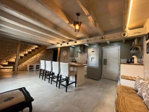 a kitchen and living room with a bar and chairs at Bergerie du Causse in Livernon