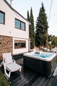 einen Whirlpool auf einer Terrasse neben einem Haus in der Unterkunft The Cypress Villa & Vineyard II in Sremska Kamenica