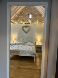 Bergerie du Causse في Livernon: غرفة نوم مع سرير مع قلب على السقف