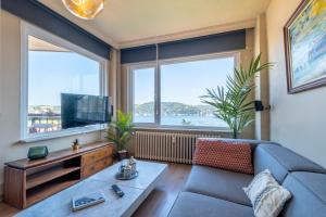 a living room with a couch and two large windows at Stunning 2Br Apt at the Brim of the Bosphorus in Istanbul