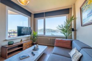 a living room with a couch and two large windows at Stunning 2Br Apt at the Brim of the Bosphorus in Istanbul