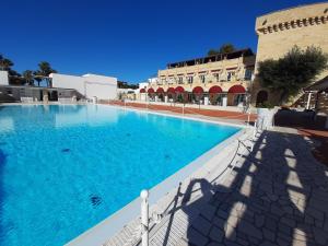 a large swimming pool in front of a building at Messapia Hotel & Resort in Marina di Leuca