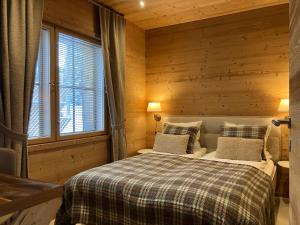 - une chambre avec un lit dans une pièce en bois dans l'établissement VILLA TUNDRA, à Ruka