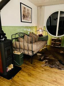 a living room with a couch and a wood stove at Eulennest - Tiny House im Habichtswald in Schauenburg