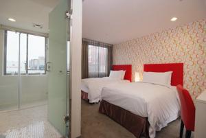 a bedroom with two beds and a walk in shower at Hotel Leisure 台中輕行旅 in Taichung