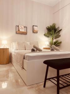 1 dormitorio blanco con 1 cama y 1 silla en Cactus Luxury suite2, en Atenas