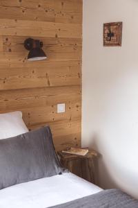 1 dormitorio con 1 cama con pared de madera en Les Hauts de Saint-Lary, en Saint-Lary-Soulan
