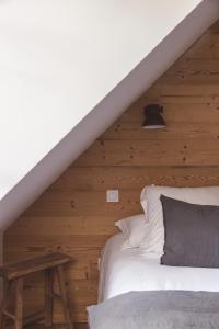 a bedroom with a bed and a wooden wall at Les Hauts de Saint-Lary in Saint-Lary-Soulan