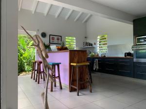 a kitchen with a counter and stools in a room at VILLA CAZARAMEL in Le Gosier